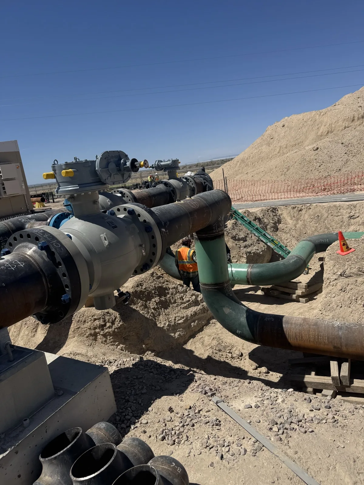 Pipe headers and large valves at the installation pit