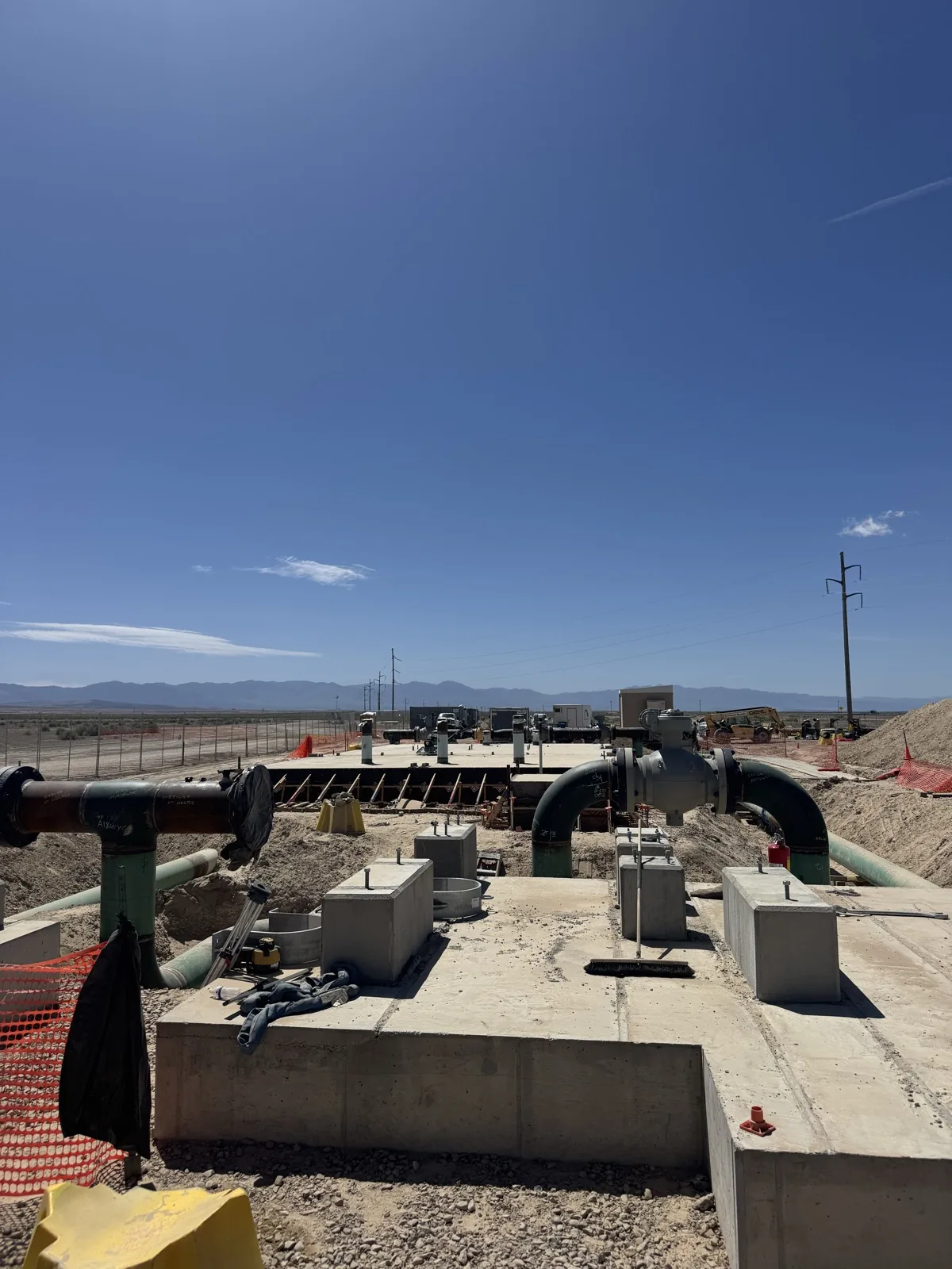 Gas manifold installed on its concrete pad with desert mountains in the distance